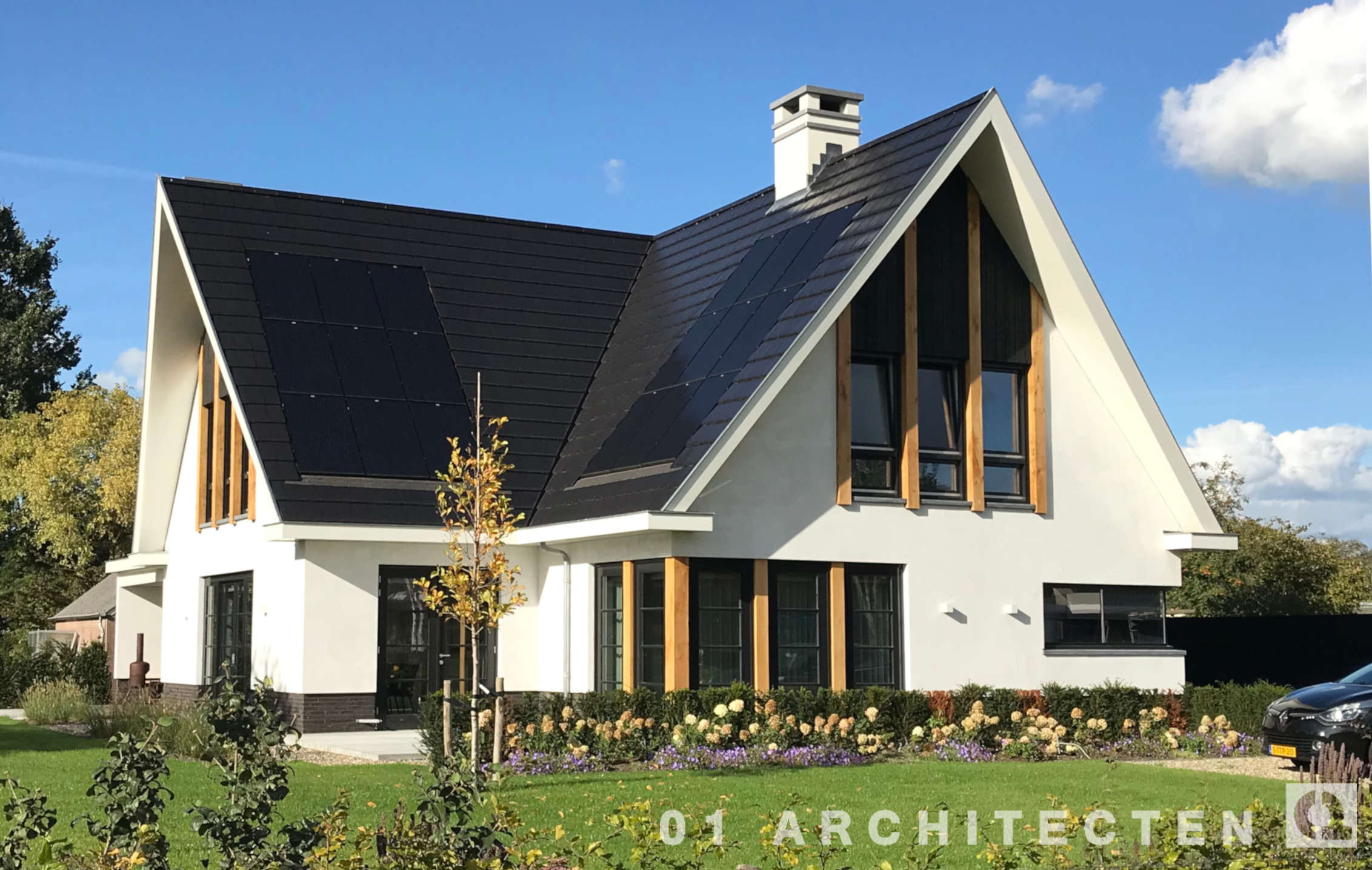 Nieuwbouw villa in Hellendoorn met wit stucwerk, eikenhouten balken en vlakke dakpannen