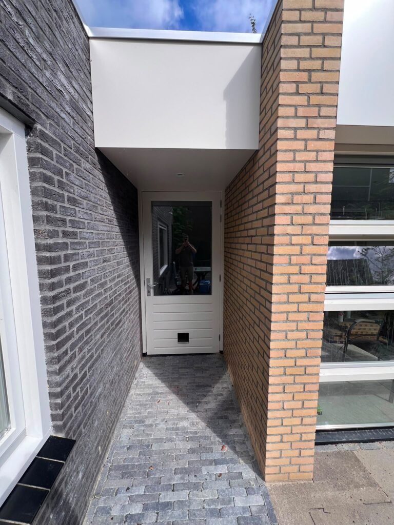 Aansluiting/achteringang van een hoogwaardige woninguitbreiding in Almere met eigentijdse detaillering en zorgvuldig afgestemde materialen