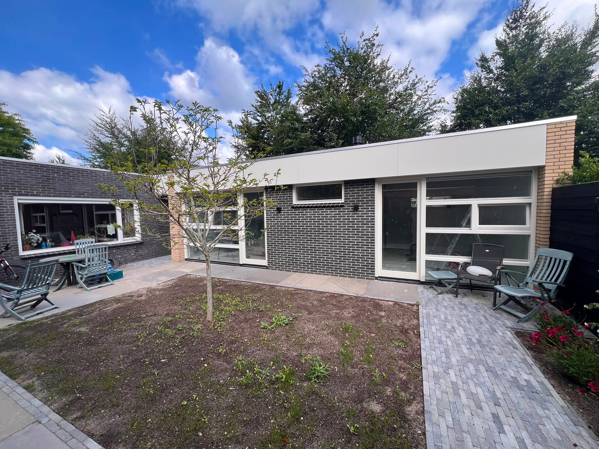 Moderne aanbouw aan bestaande woning in Almere met grote glaspartijen en sterke relatie tussen woning en tuin