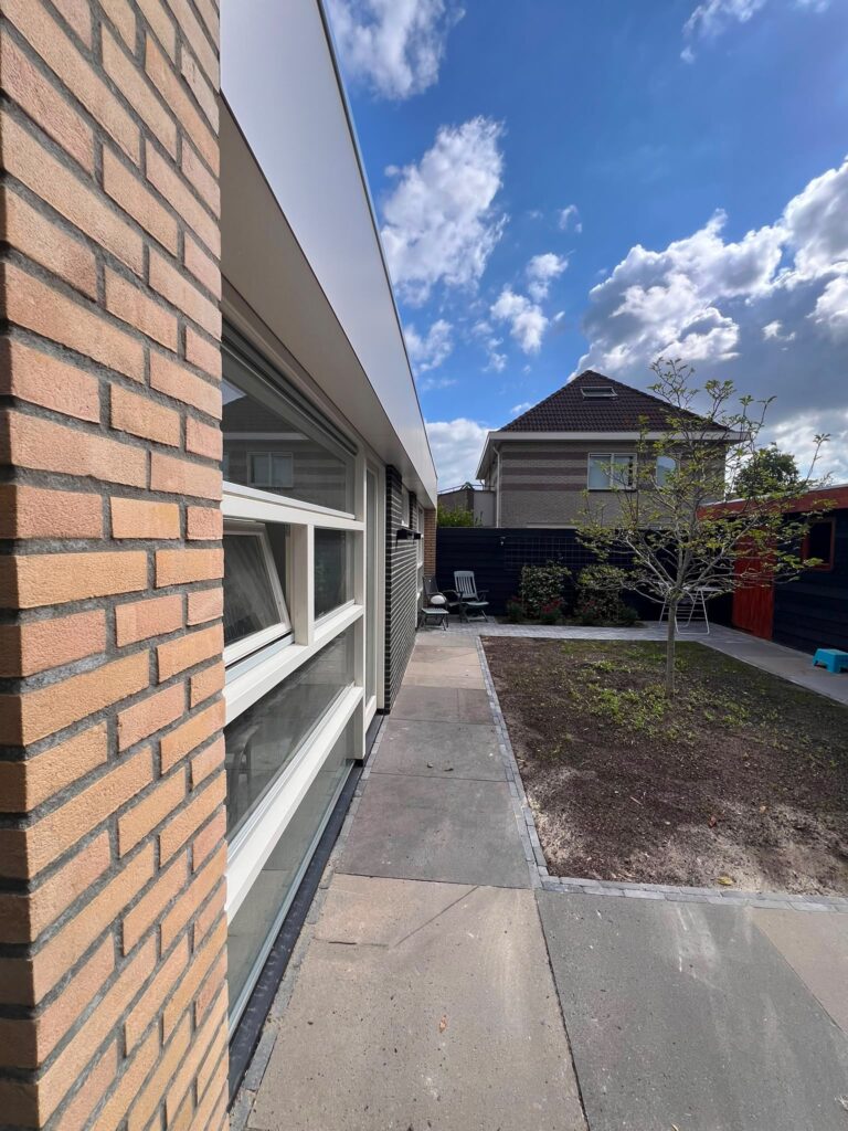 Moderne aanbouw in Almere met grote glasvlakken en een directe verbinding tussen woning en tuin