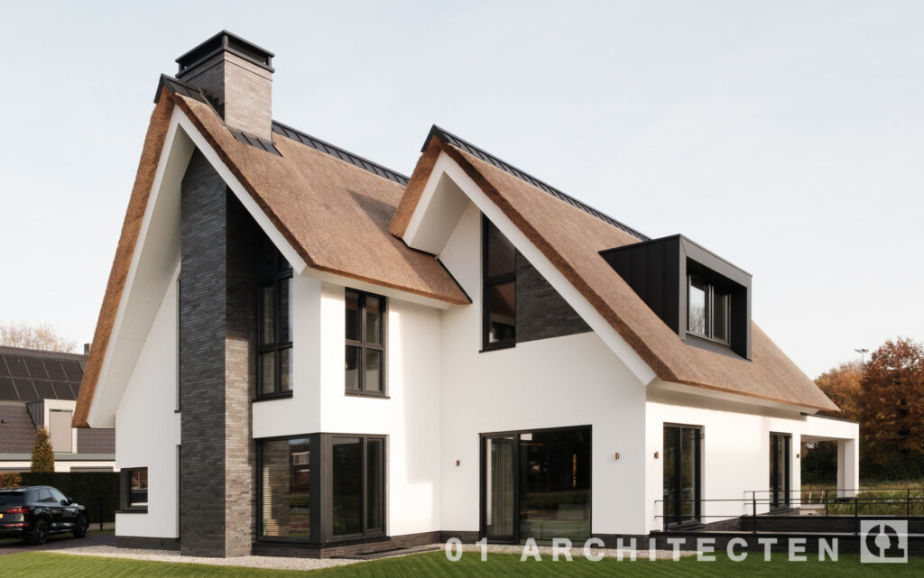Rietgedekte villa in Gramsbergen met witte gevels, donkere accenten en grote glaspartijen.