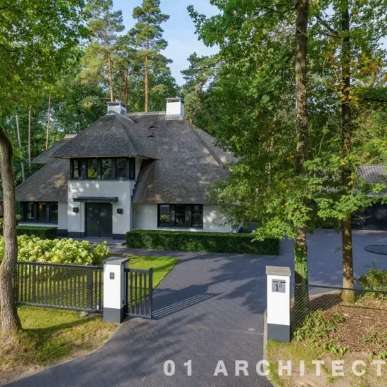 ugchelen-bosrijke-omgeving.webp Rietgedekte villa in Ugchelen gezien vanaf de oprijlaan, met vrijstaand bijgebouw en bosrijke tuin