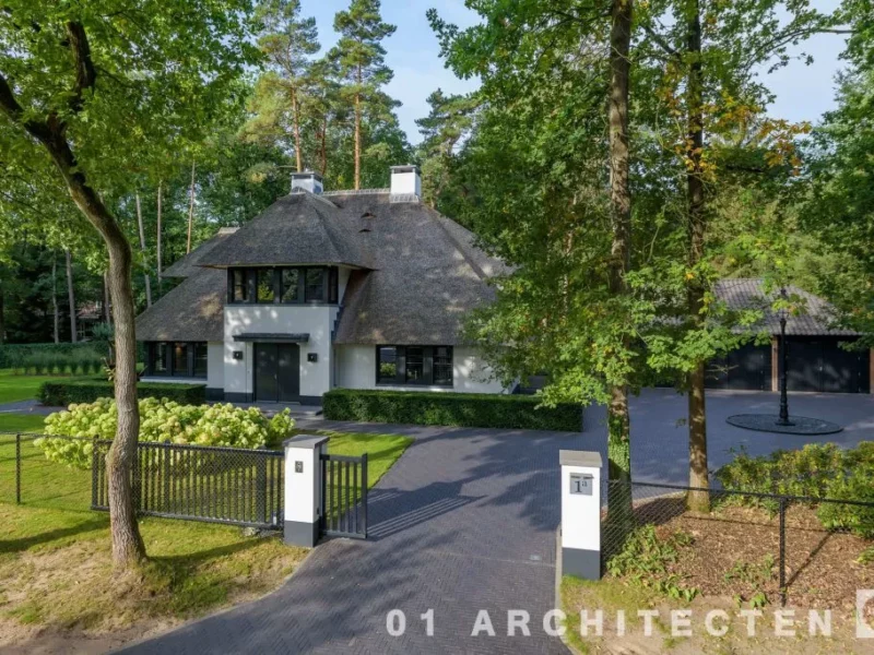 ugchelen-bosrijke-omgeving.webp Rietgedekte villa in Ugchelen gezien vanaf de oprijlaan, met vrijstaand bijgebouw en bosrijke tuin
